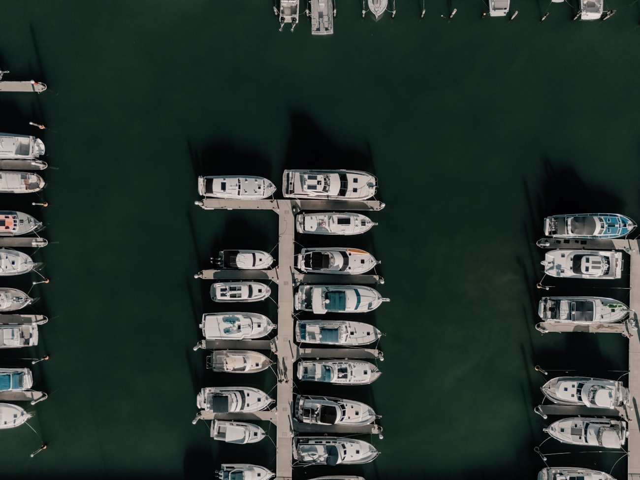 Top-down aerial view of boats berthed in rows of marina slips