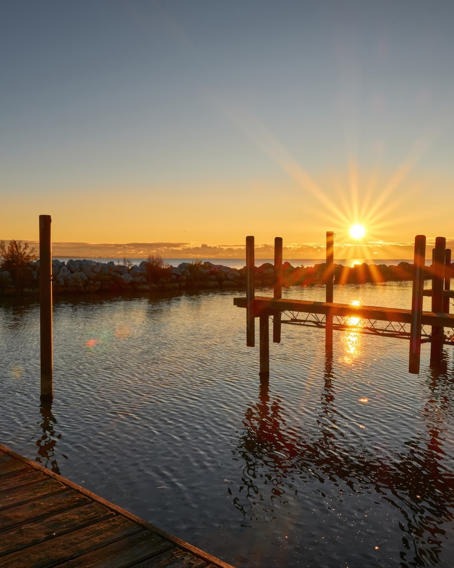 Sunrise over a calm marina basin with empty slips and wooden pilings